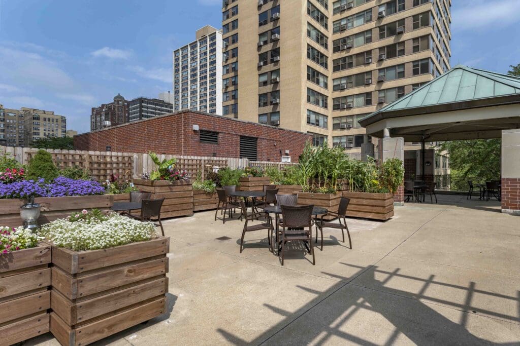 Exterior image of The Hallmark patio with raised garden beds and comfortable seating.