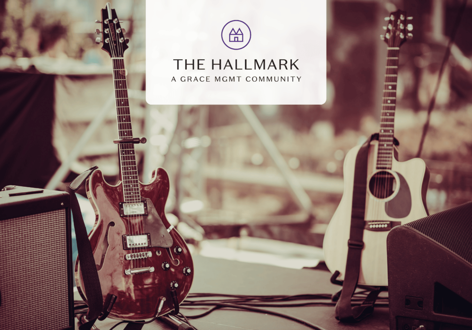 Stage setup with electric and acoustic guitars and an amplifier, centered by a white logo card that reads 'THE HALLMARK' and 'A GRACE MGMT COMMUNITY'