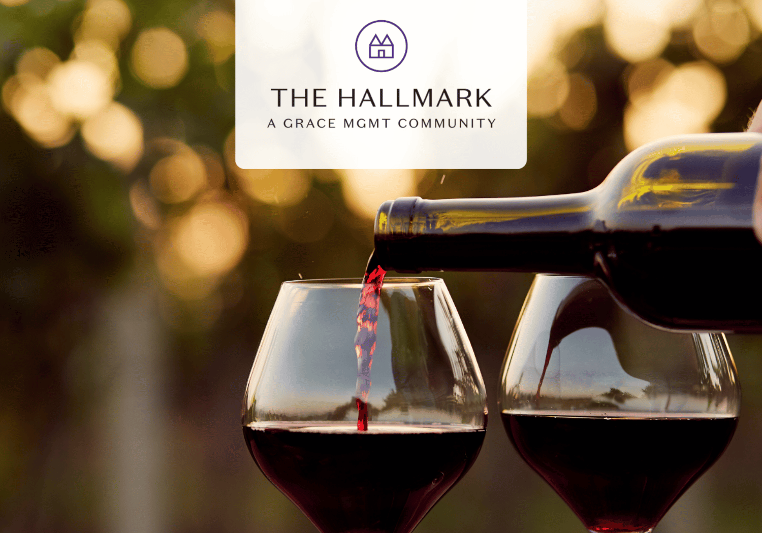 Promotional image: red wine being poured into two glasses with a The Hallmark logo banner at the top center.